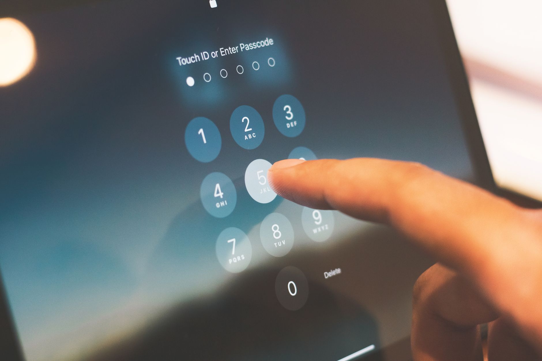 Finger entering a passcode on a smartphone security screen